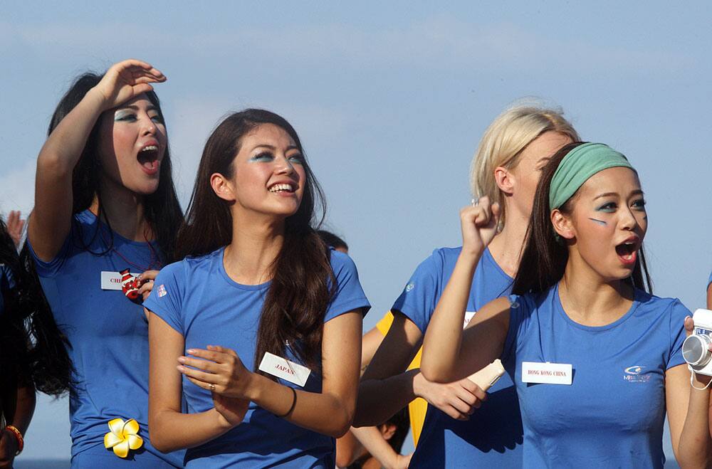 Miss World pageant contestants from left, Miss China Wei Wei Yu, Miss Japan Michiko Tanaka and Miss Hong Kong Jacqueline Wong, cheer their team during a beach game in Nusa Dua, Bali, Indonesia.