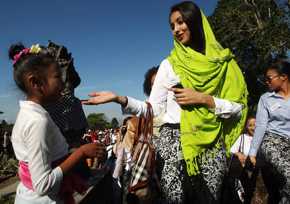 Miss India Navneet Dhillon, center, and other Miss World Pageant contestants are greeted by a Balinese girl during their visit to a Hindu temple in Besakih, Bali, Indonesia.