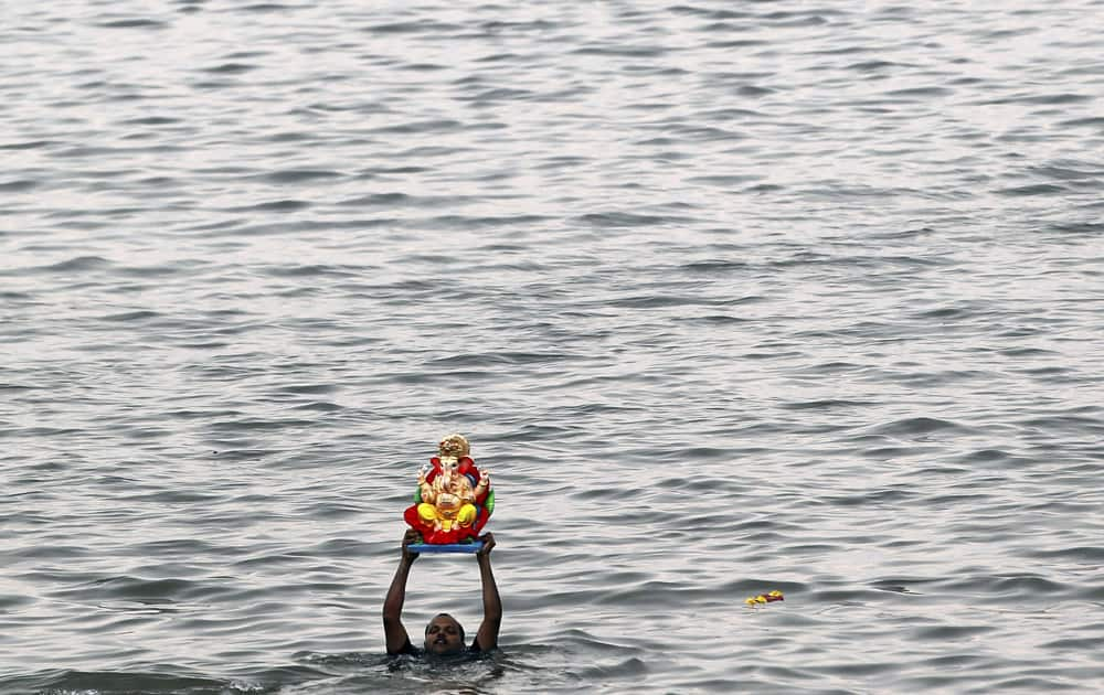 A devotee prepares to immerse an idol of elephant-headed Hindu god Ganesha in the Arabian Sea during Ganesh Chaturthi festival celebrations in Mumbai.