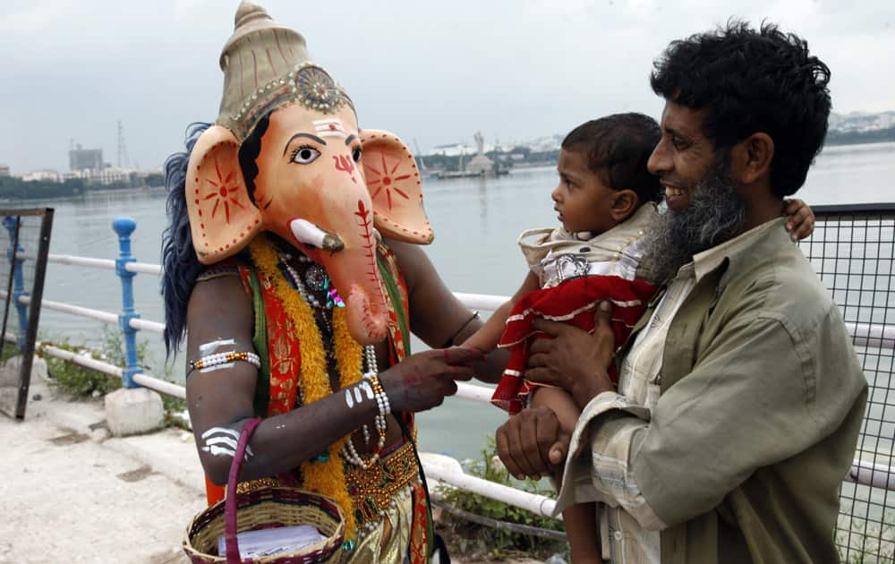 A Hindu devotee wearing a mask of elephant-headed Hindu god Ganesha greets people at Hussain Sagar Lake during Ganesh Chaturthi festival celebrations in Hyderabad.