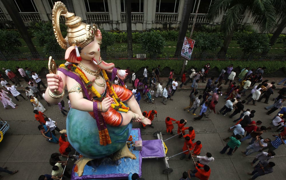 Devotees take an idol of elephant headed Hindu god Ganesha through a street for immersion in the Arabian Sea in Mumbai.