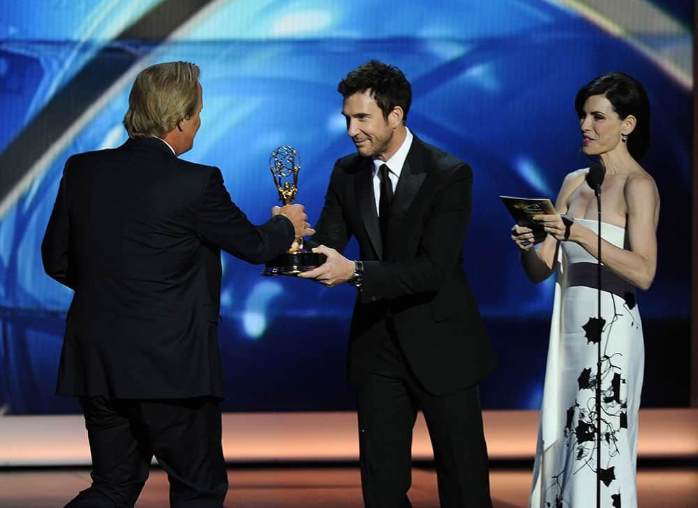 Jeff Daniels, left, accepts the award for outstanding lead actor in a drama series for his role on “The Newsroom” from presenters Julianna Margulies and Dylan McDermott, center, at the 65th Primetime Emmy Awards at Nokia Theatre.