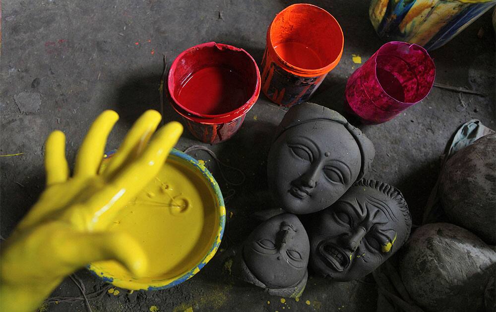 An artisan mixes colors to paint idols of Hindu goddess Durga ahead of Durga Puja festival in Gauhati.