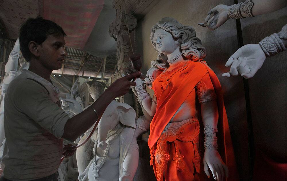 An artisan paints idols of Hindu goddess Durga ahead of Durga Puja festival in Gauhati.