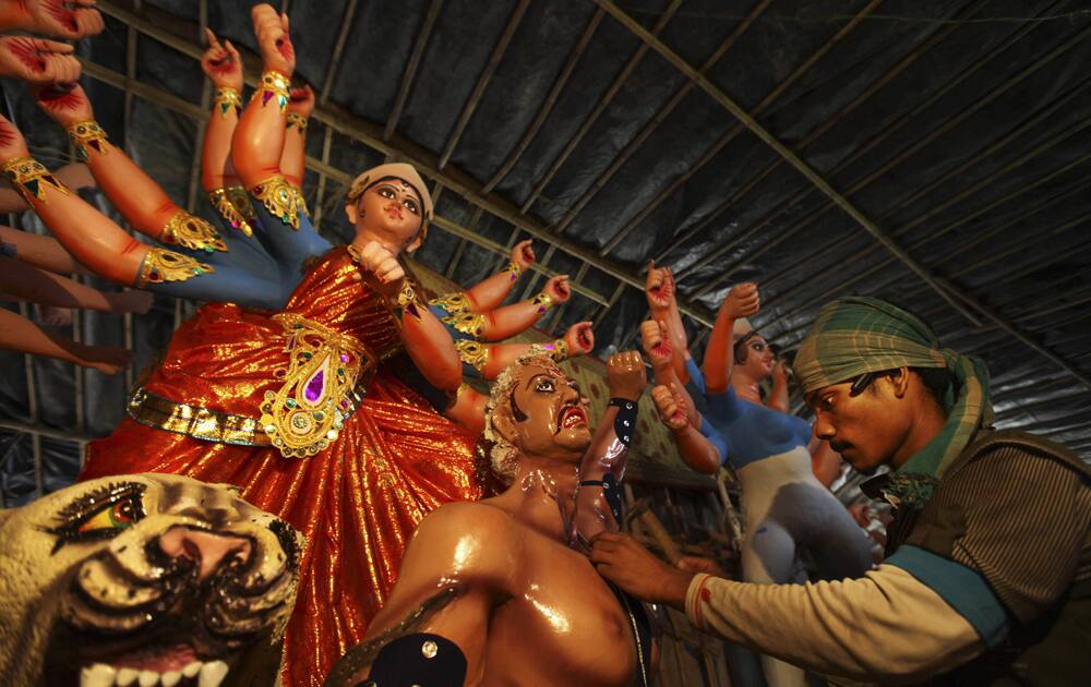 Artist works on idols of Hindu gods and goddesses in his workshop ahead of the Durga Puja festival, in New Delhi.