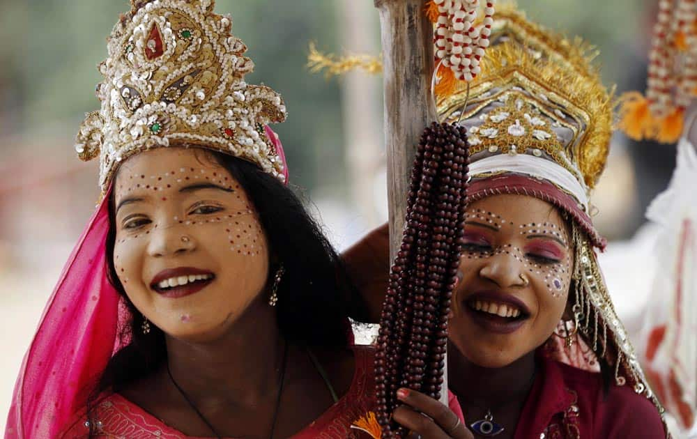 Girls dressed as Goddess Laxmi share a light moment as they wait to collect money from devotees ahead of the nine-day Hindu festival of Navratri at Sangam.