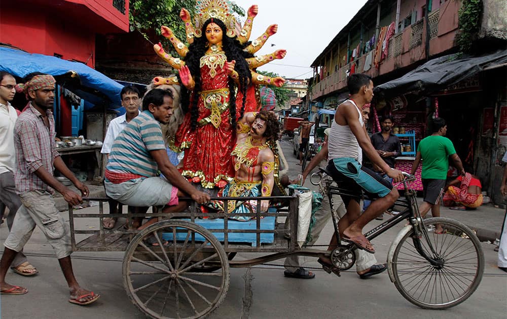 An idol of Hindu goddess Durga is transported on a cycle rickshaw to a venue of worship in Kolkata.