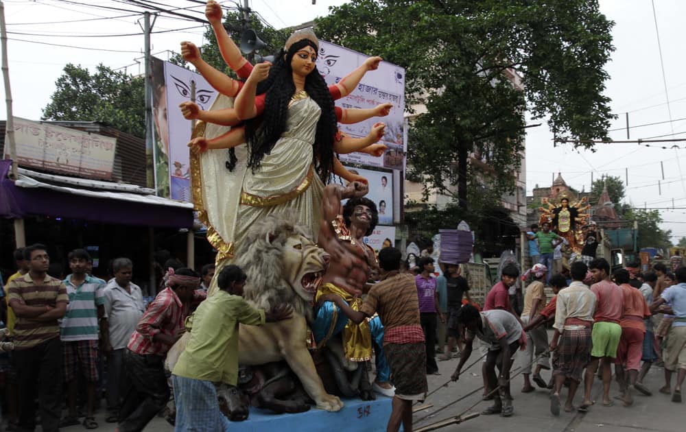 An idol of Hindu goddess Durga is transported by laborers to a venue of worship in Kolkata.