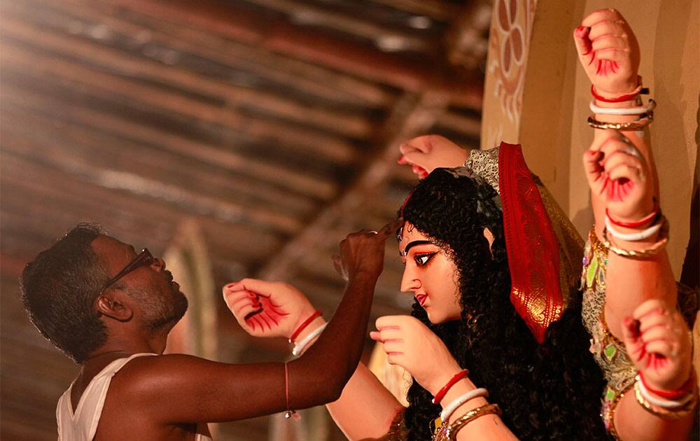 An Indian artist gives the finishing touches to an idol of Hindu goddess Durga ahead of Durga Puja festival in Mumbai.