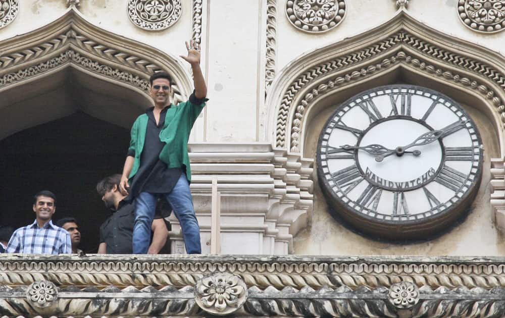 Bollywood actor Akshay Kumar waves from the top of a 16th century historical landmark Charminar during a promotional event for of upcoming movie 