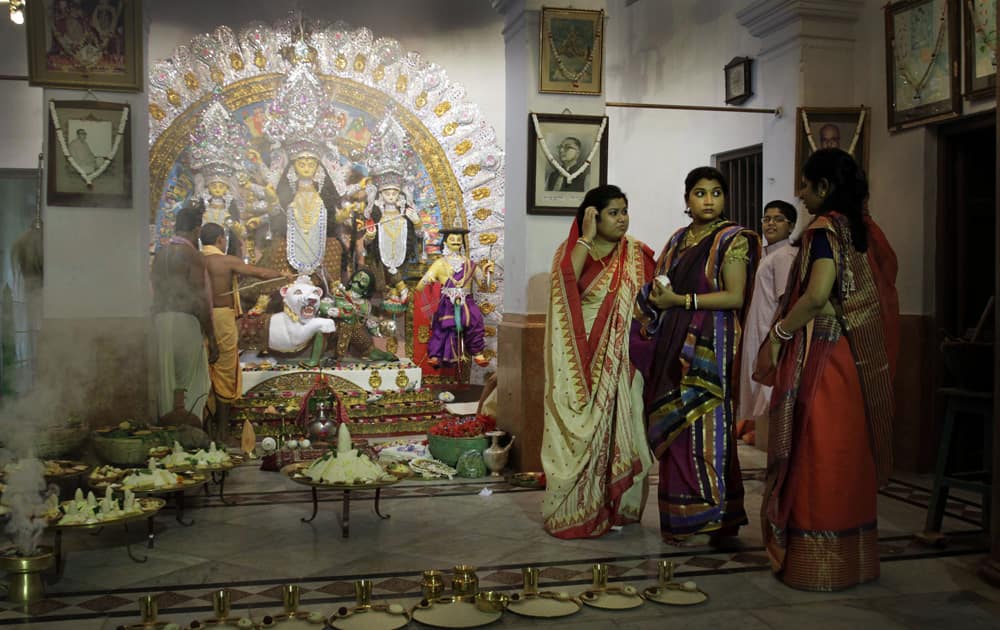 Bengali women in their traditional attire get ready for a ritual in front of the Hindu goddess Durga idol during Durga Puja festival, in Kolkata.