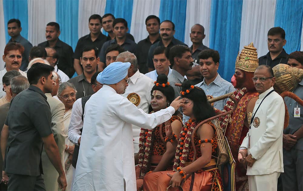 Prime Minister Manmohan Singh, blue turban, performs a ritual before people dressed as Hindu deities Ram, Lakshman and Hanuman during Dussehra celebrations in New Delhi.