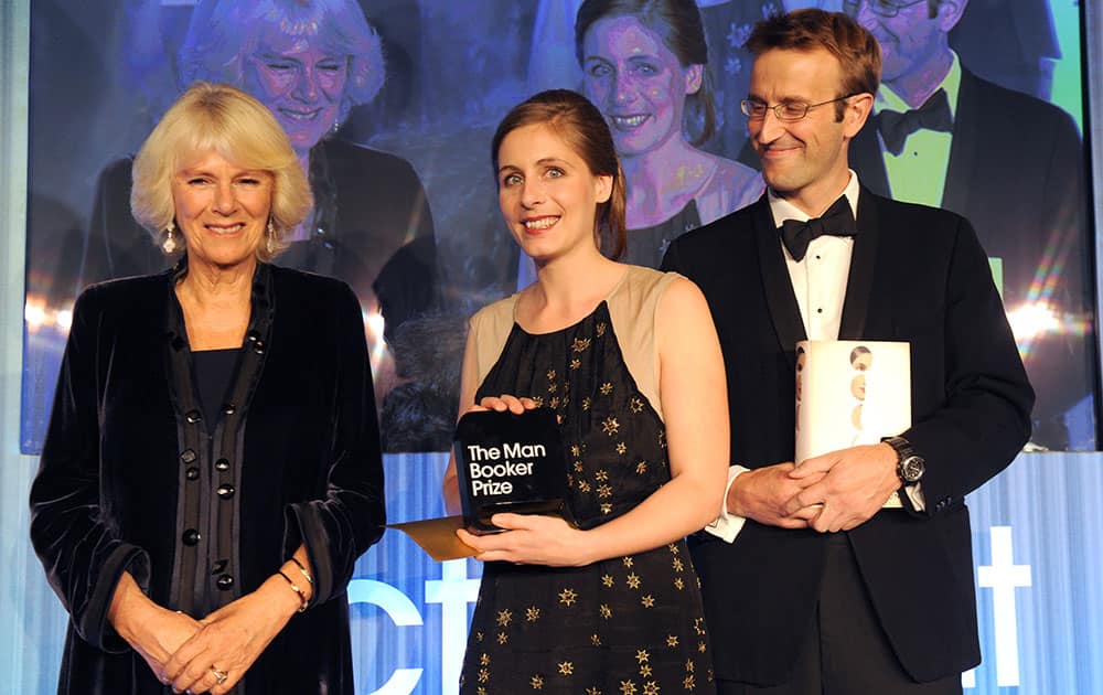 New Zealand author Eleanor Catton, holds her prize and stands with the Duchess of Cornwall and Robert Macfarlane, Chair of judges, after winning the Man Booker Prize for Fiction, in central London.