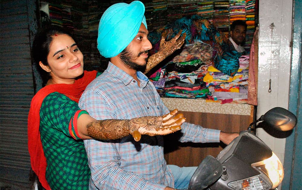 A woman after applying 'Mehndi' on her hands on the eve of Karva Chauth at a market in Patiala.