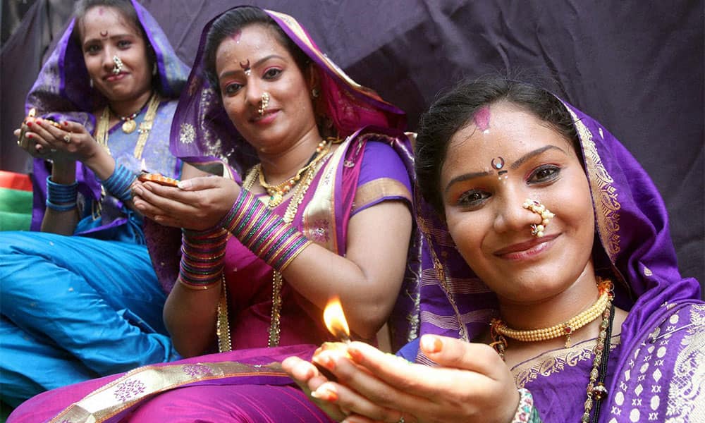 Artists pose with 'diya' during an event to celebrate Diwali in Mumbai.