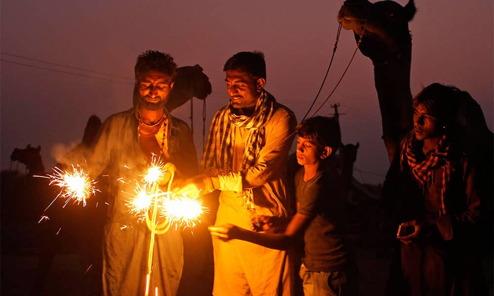 Camel herders, gathered for the annual cattle fair, play with firecrackers on the eve of Diwali in Pushkar.