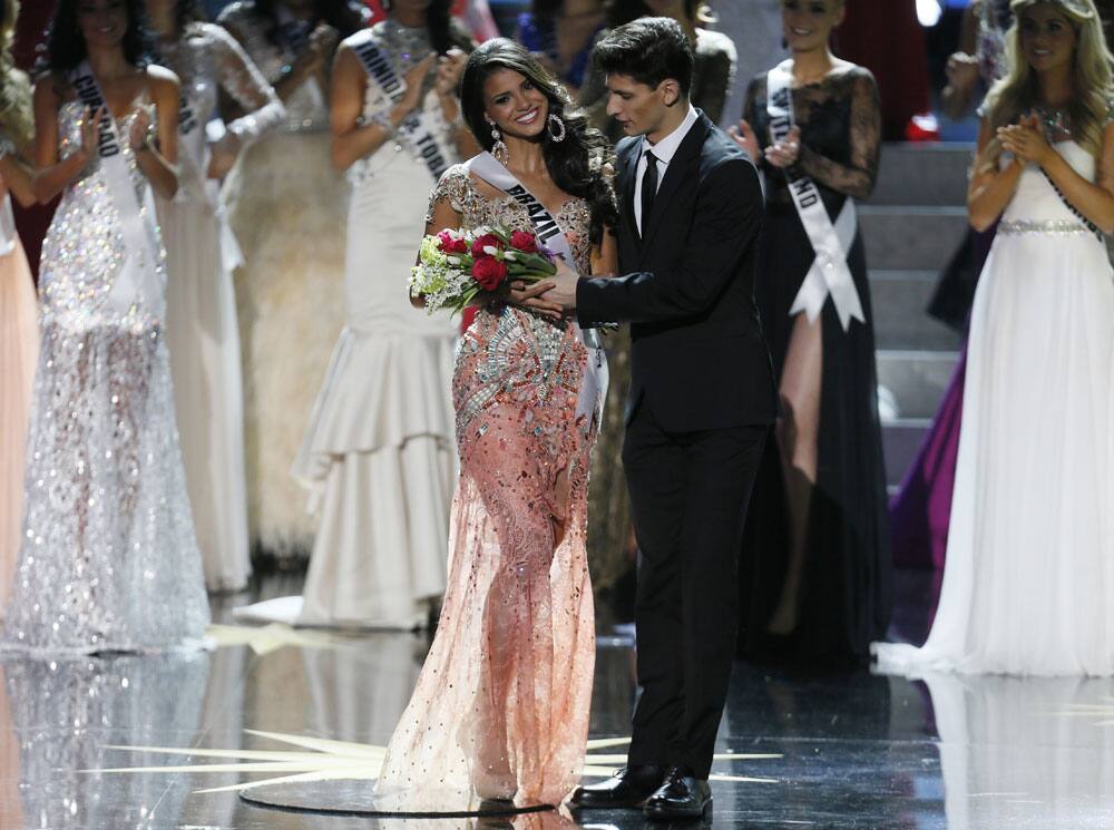 Miss Brazil Jakelyne Oliveira, left, receives a bouquet of flowers before leaving the 2013 Miss Universe pageant in Moscow, Russia.