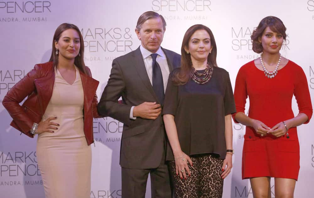 Marks & Spencer chief executive Marc Bolland, poses for photographers with Indian businesswoman Nita Ambani and Bollywood actors Sonakshi Sinha, Bipasha Basu, during the opening of their biggest store in India, Mumbai.