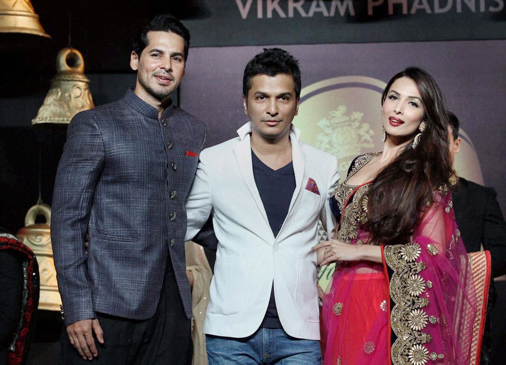 Bollywood actors Malaika Arora Khan and Dino Morea, showcase a creation by designer Vikram Phadnis (C) during a fashion event in Mumbai.