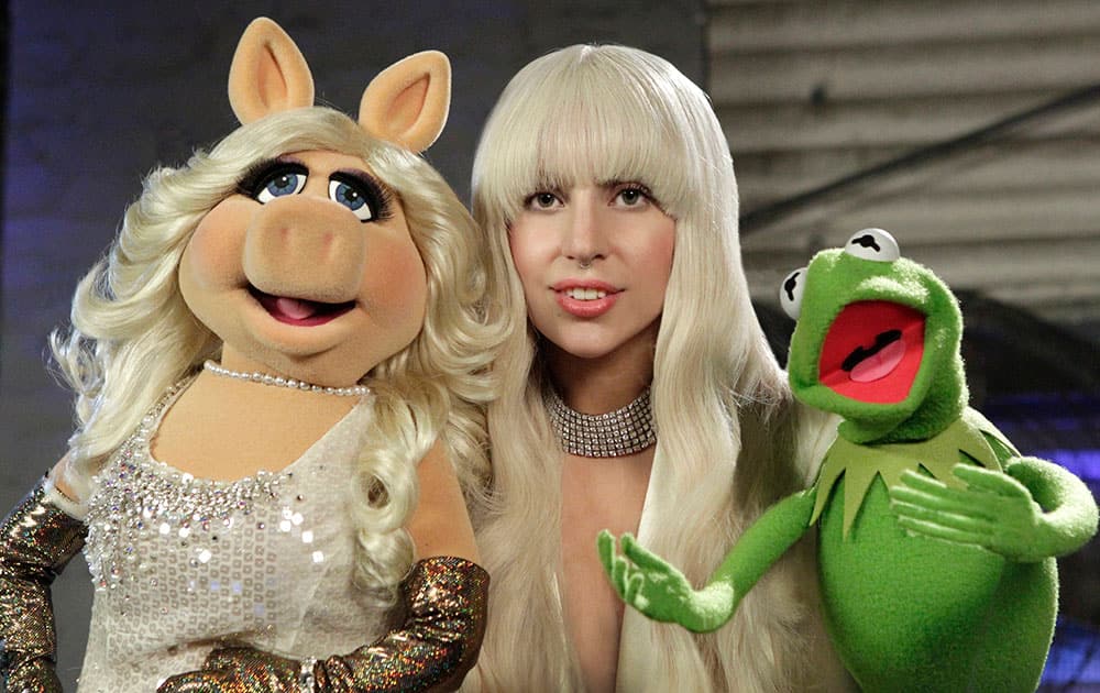 This image released by ABC shows performer Lady Gaga, center, with muppet characters Miss Piggy, left, and Kermit the Frog in a promotional photo for the upcoming show 