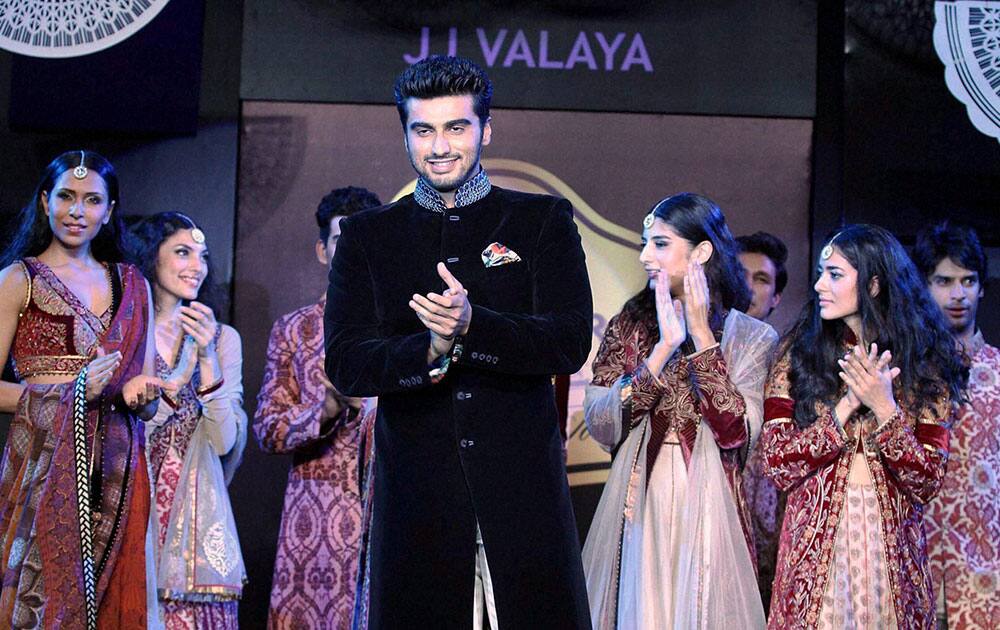 Bollywood film actor Arjun Kapoor (C) showcases a creation by designer JJ Valaya during an event in Mumbai.