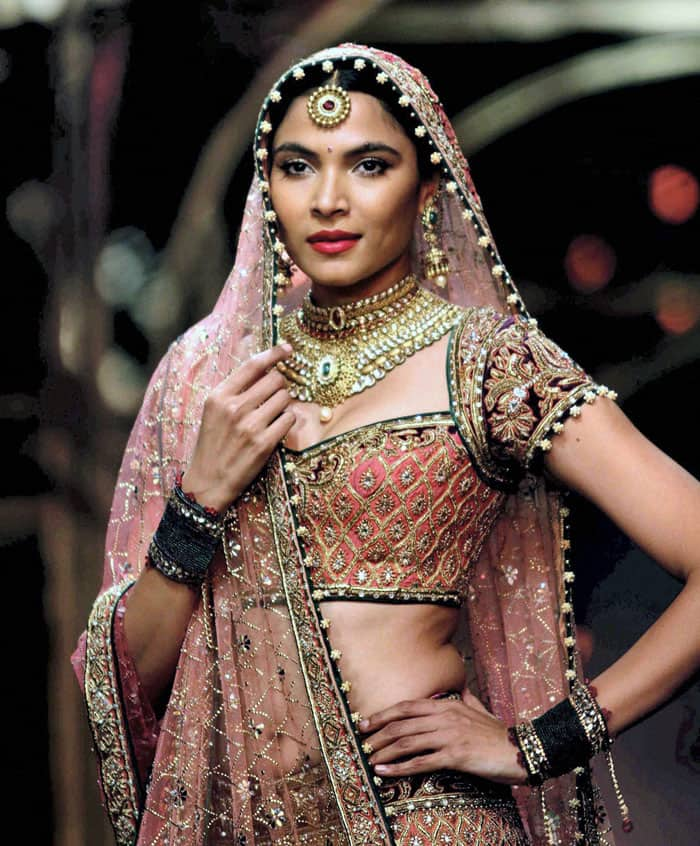 A model walks the ramp showcasing an outfit designed by Tarun Tahiliani during the Aamby Valley India Bridal Fashion Week in Mumbai.