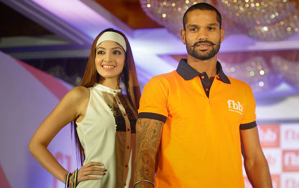 Shikhar Dhawan (R) shares the stage with a model at a promotional event in Mumbai. Pic Courtesy: DNA