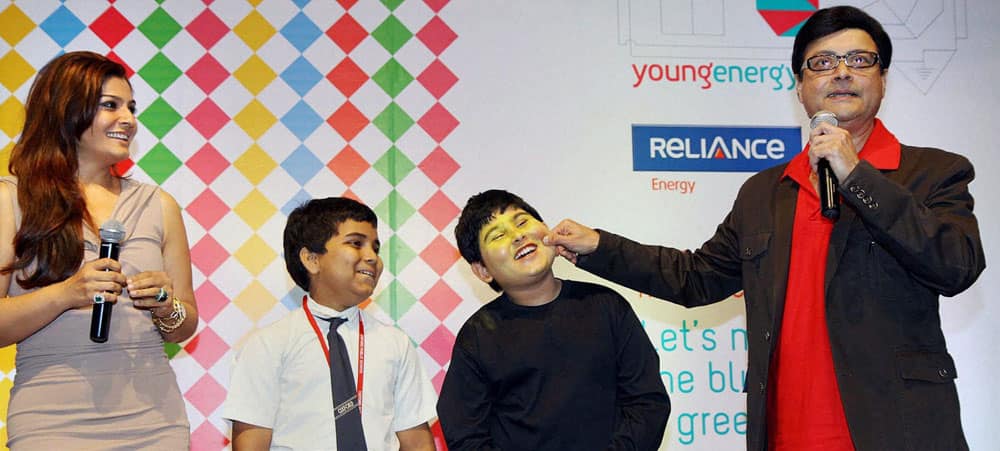 Bollywood actors Sachin Pilgaonkar and Raveena Tandon with school children during an event in Mumbai.