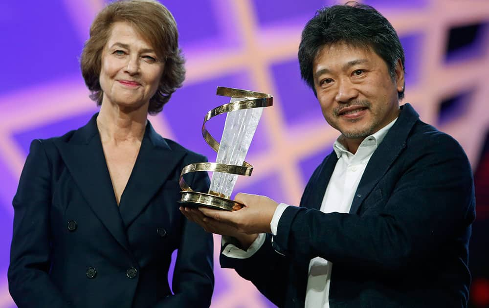 Japanese director, screenwriter, and producer Hirokazu Koreeda receives a trophy in tribute to his lifetime career from British actress Charlotte Rampling, left, at the Marrakech International Film Festival.