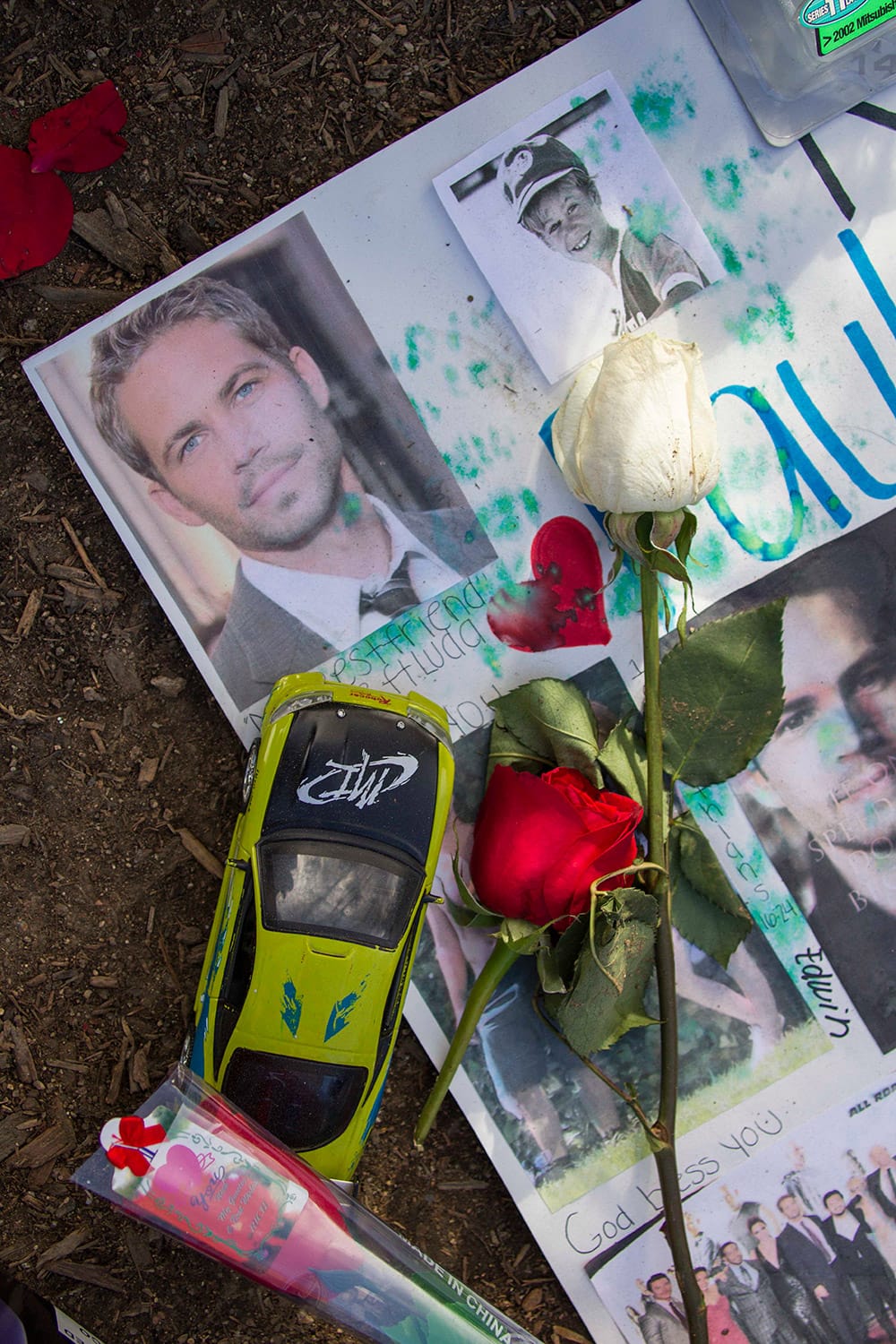 Flowers and messages are left at a memorial rally and car cruise in Valencia, Calif., to remember actor Paul Walker and his friend Roger Rodas, who died in a fiery car crash last Saturday.