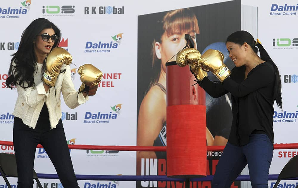 Bollywood actress Sushmita Sen, left, and Indian boxer Mary Kom, right have a `friendly bout` during the release of the autobiography of Mary Kom, in Gauhati.