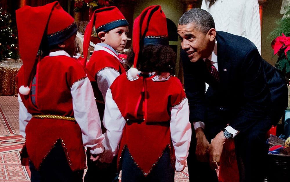 President Barack Obama greets children dressed like elves at the National Building Museum in Washington.