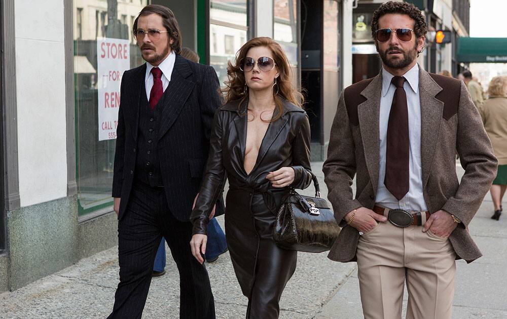 Christian Bale, left, as Irving Rosenfeld, Amy Adams as Sydney Prosser, and Bradley Cooper as Richie Dimaso in a scene from Columbia Pictures' film, `American Hustle.`