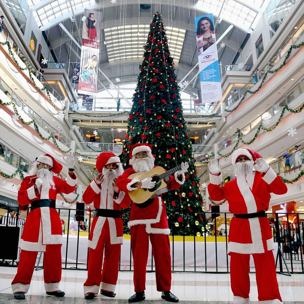 Men dressed as Santa Claus perform at a mall ahead of Christmas celebrations in Thane, Mumbai.