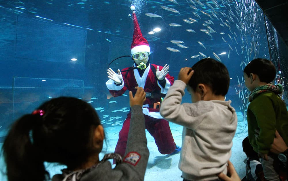 A diver dressed in a Santa Claus costume greets children at the Coex Aquarium in Seoul, South Korea.