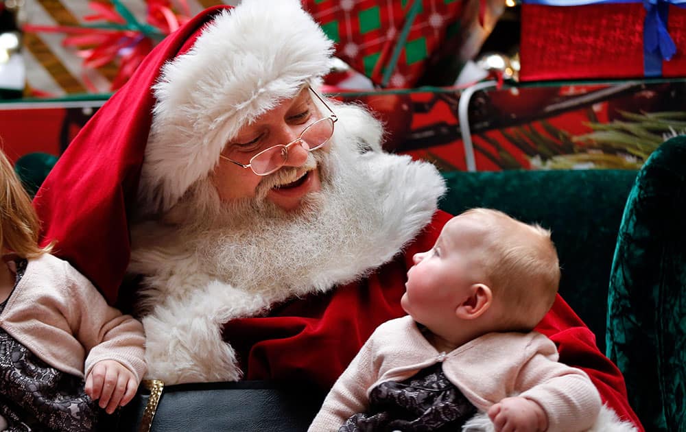 A man portraying Santa Claus talks to 6-month-old Aubree-Jane Halladay, of Scarborough, Maine, at a mall in South Portland, Maine.