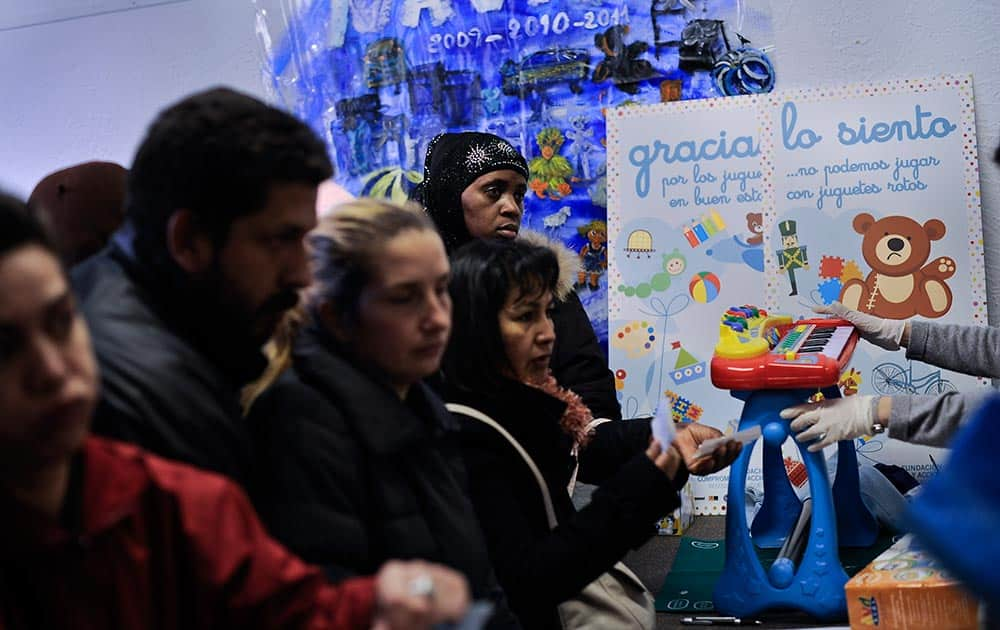 People await free distribution of Christmas toys, which are being given to families with little money, at a local town hall in Pamplona, northern Spain.