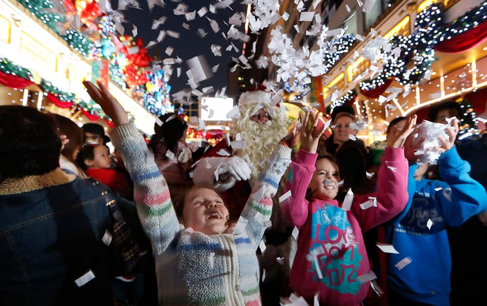 Visitors play with shredded papers with Christmas decorations to celebrate the festival season at a shopping mall in Hong Kong.