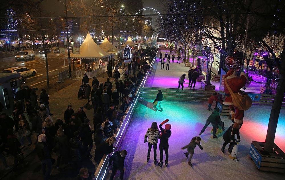 People skate at the Christmas market on the Champs Elysees avenue in Paris.