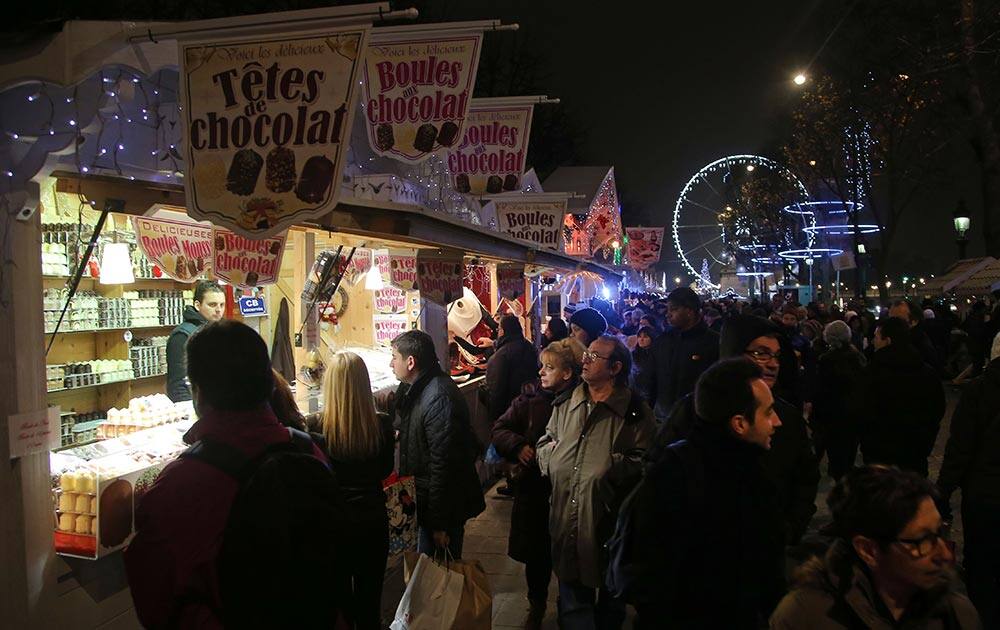 People stroll along the Champs Elysees avenue at the Christmas market in Paris.