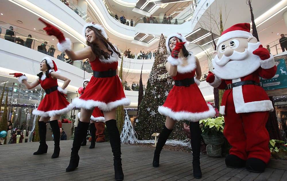 Employees dressed as Santa Claus perform as part of a shopping mall's Christmas celebrations in Seoul, South Korea.