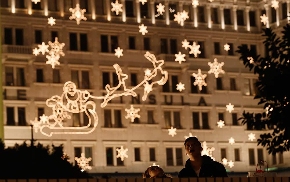 A couple look at the illuminated decoration to celebrate the festival season during Christmas eve in Hong Kong.