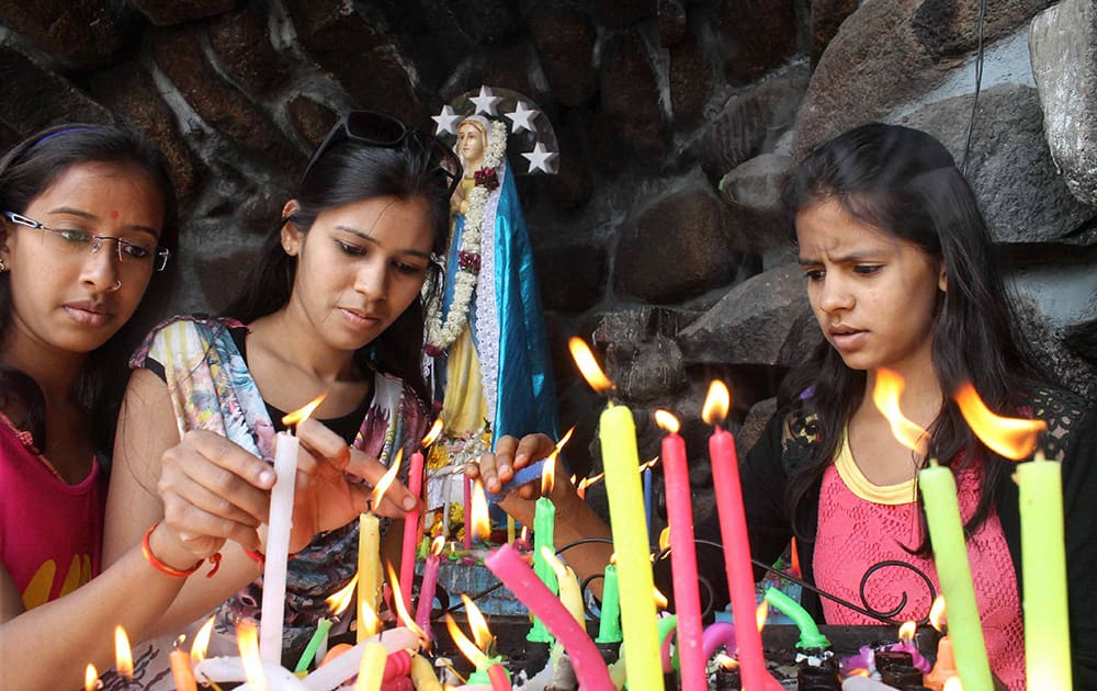 Girls light candles at S.Joseph church on the occasion of Christmas Day in Hyderabad.