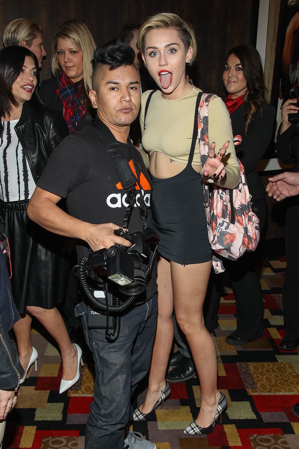 Celebrity photographer Luis Martinez and singer Miley Cyrus arrive at the 'Britney Spears: Piece of Me' Planet Hollywood Launch Party', in Las Vegas.