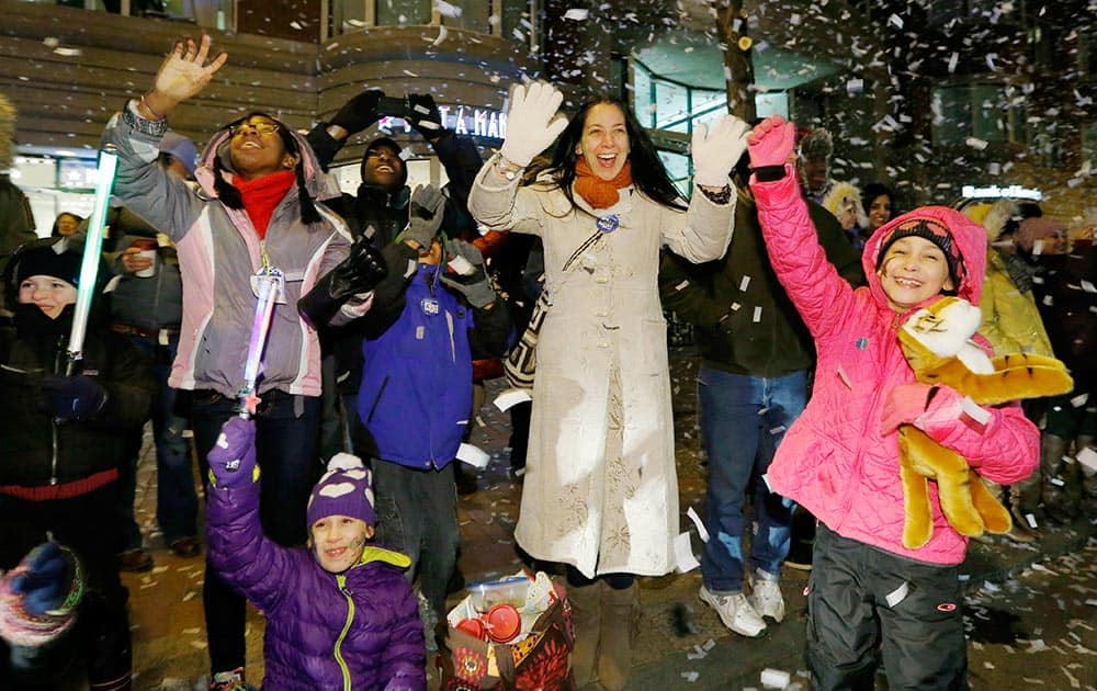 Spectators cheer as confetti falls during a parade down Boylston Street as part of New Year's Eve celebrations in Boston.