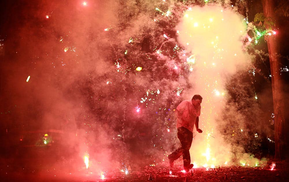 A man runs as firecrackers burst around him, on the street during the New Year celebrations in Mumbai.