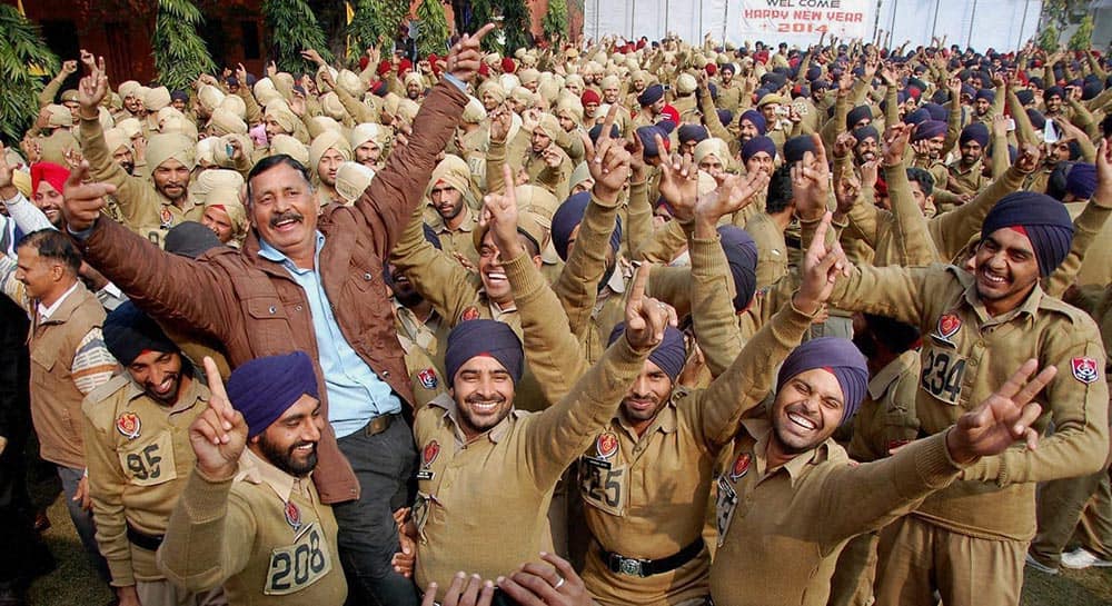Policemen take part in a yoga laughter therapy session on the first day of New Year 2014 at Punjab Armed Police Acadamy in Jalandhar.