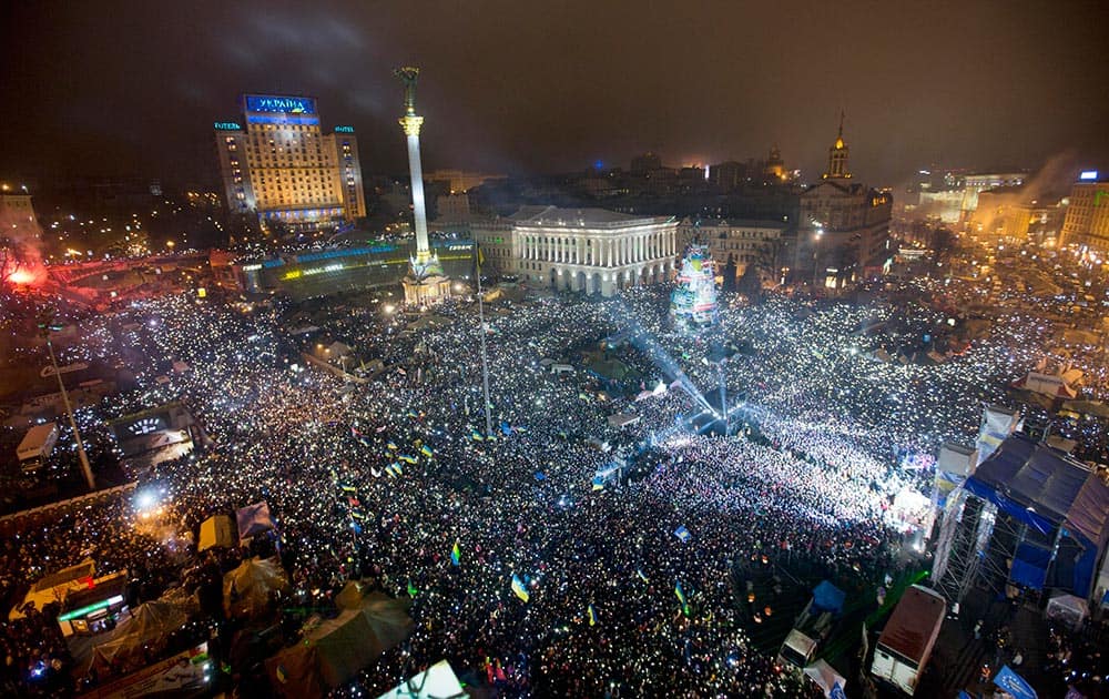 Pro-European Union activists hold light as they sing the Ukrainian national anthem, celebrating the New Year in the Ukrainian capital Kiev's main square.