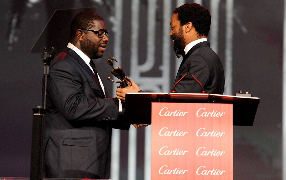 Chiwetel Ejiofor, right, presents the director of the year award to Steve McQueen for `12 Years a Slave` at the Palm Springs International Film Festival Awards Gala at the Palm Springs Convention Center.