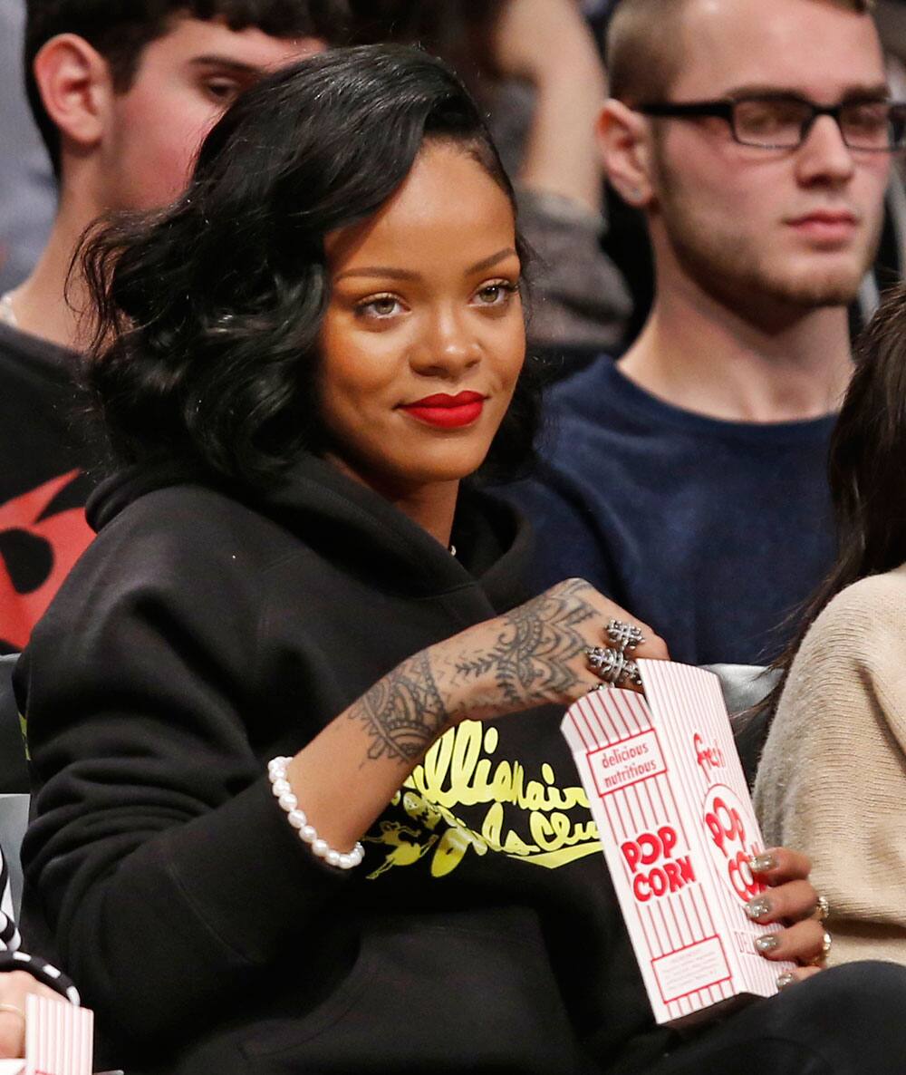 Singer Rihanna watches the Atlanta Hawks face the Brooklyn Nets in an NBA basketball game at the Barclays Center, in New York.
